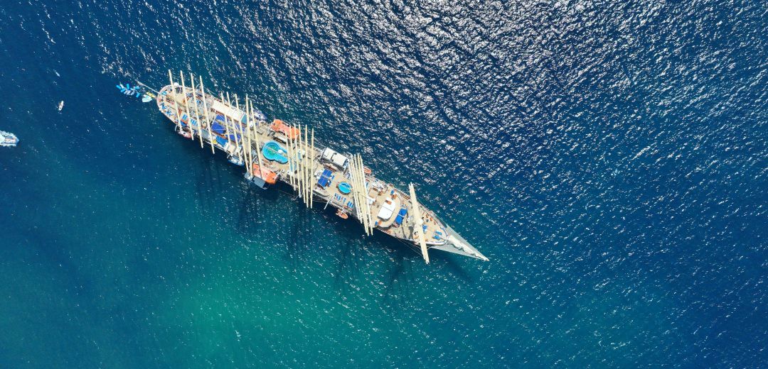 Segelschiff auf dem Meer während einer Hundekreuzfahrt mit Beiboot im Vordergrund